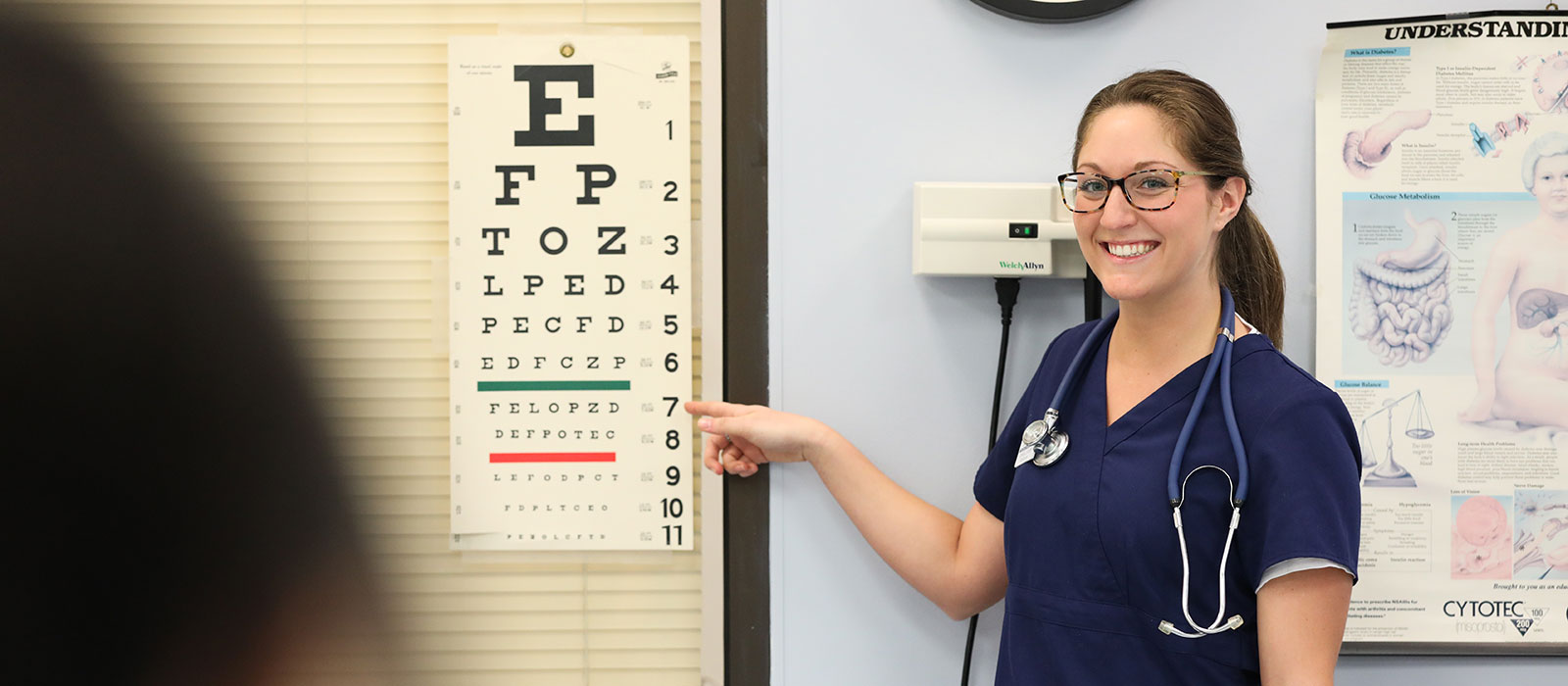 Student pointing at eye chart