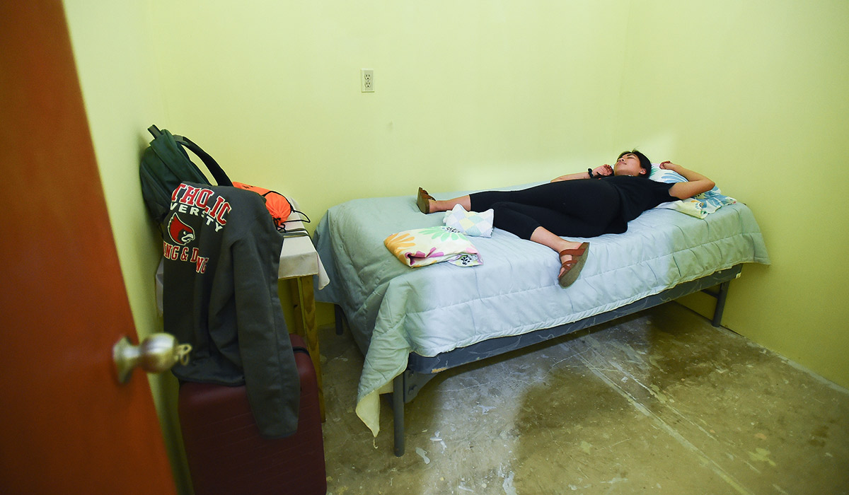 An exhausted nursing student naps on her Puerto Rico residence hall bed