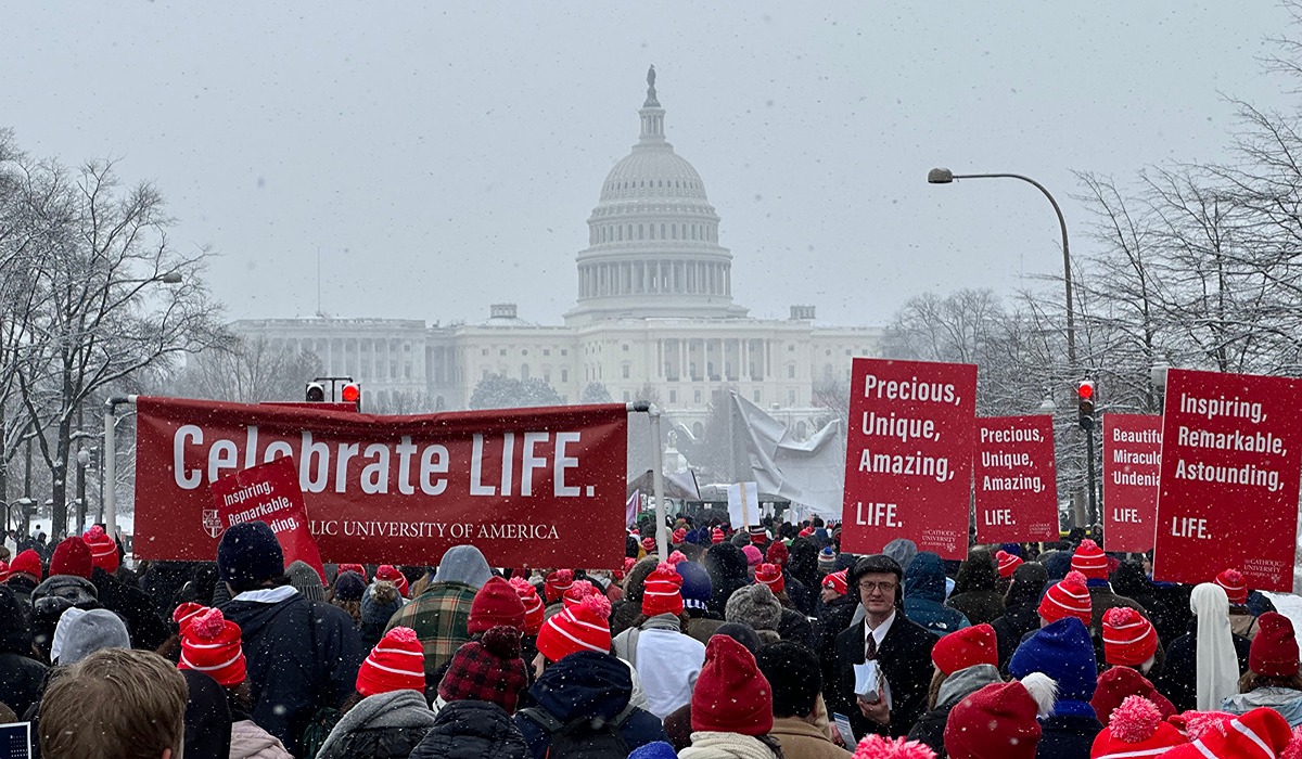 Crowd at the Capitol: Participants display red banners in a snowy march at the Capitol.