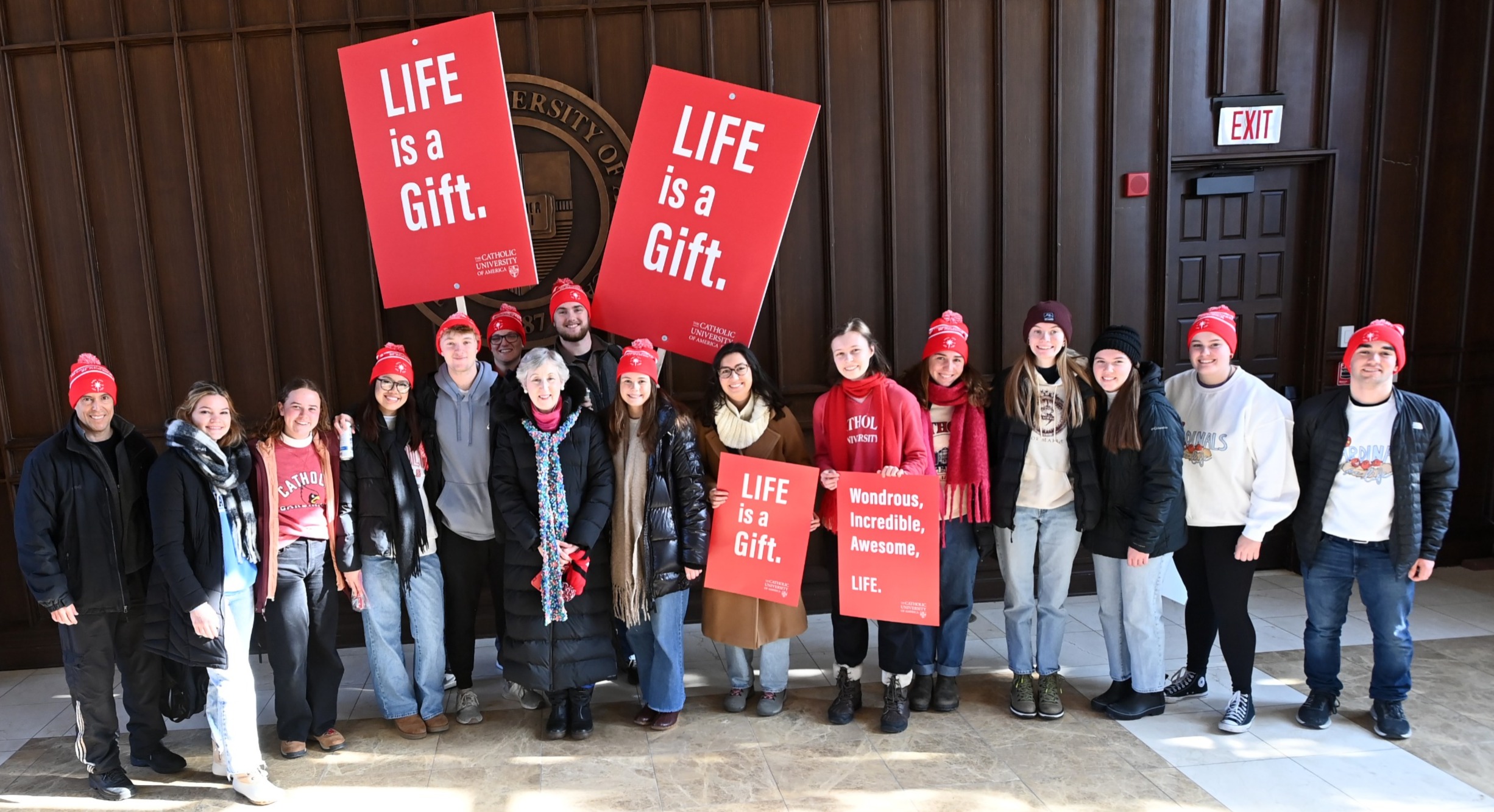 Group with "LIFE is a Gift" Banners: Professor Santiago Solares, Dean Marie Nolan, and Conway School of Nursing students hold "LIFE is a Gift" banners at Catholic University.