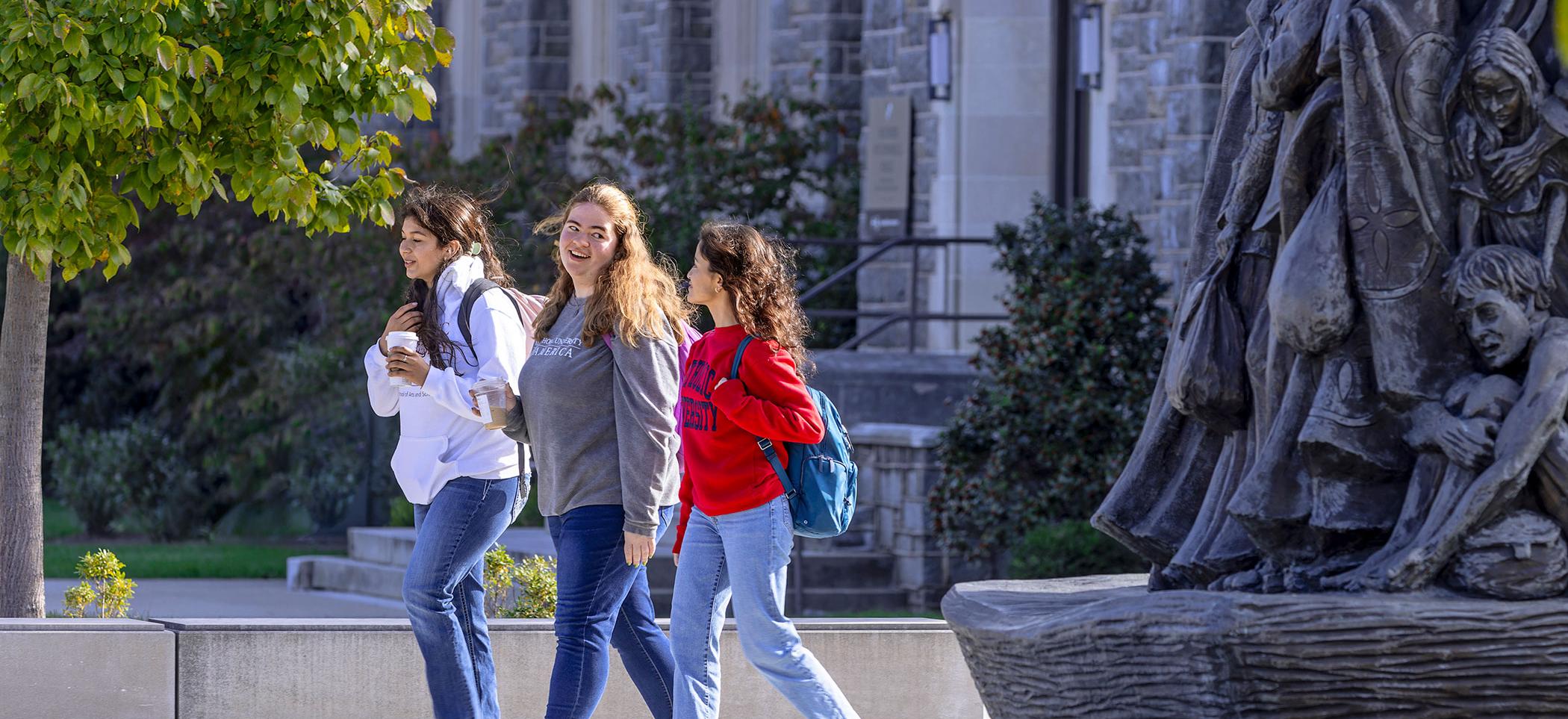 Students walking near Angels Unaware statue.