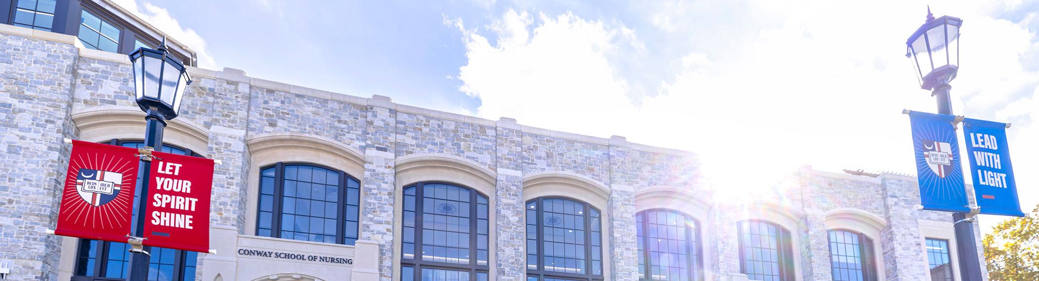 Conway Building exterior with banners and sky.