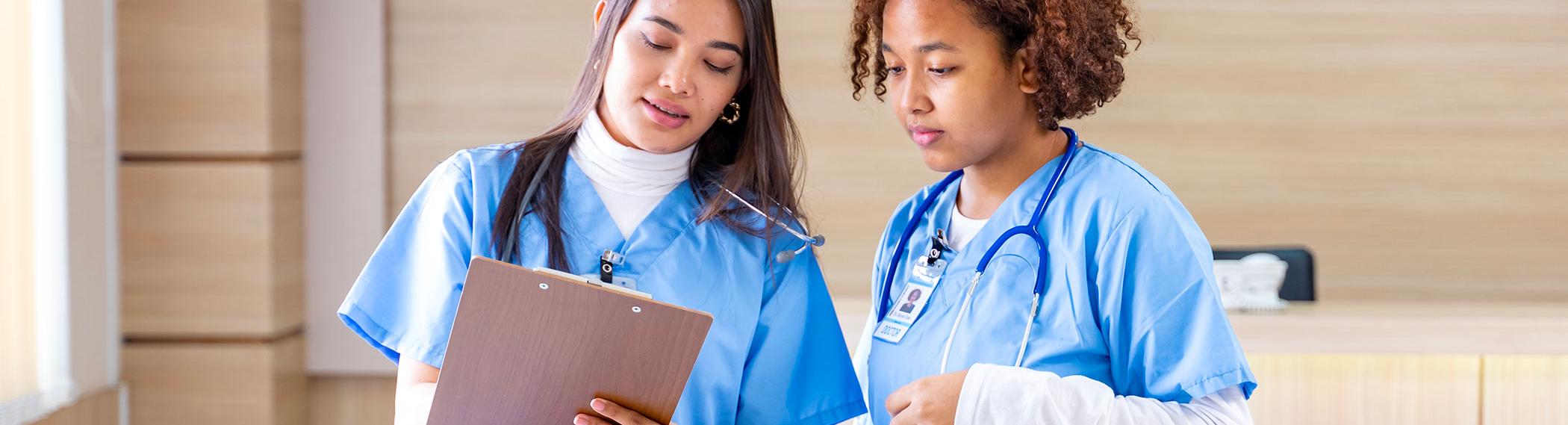 An experienced nurse mentors a student.