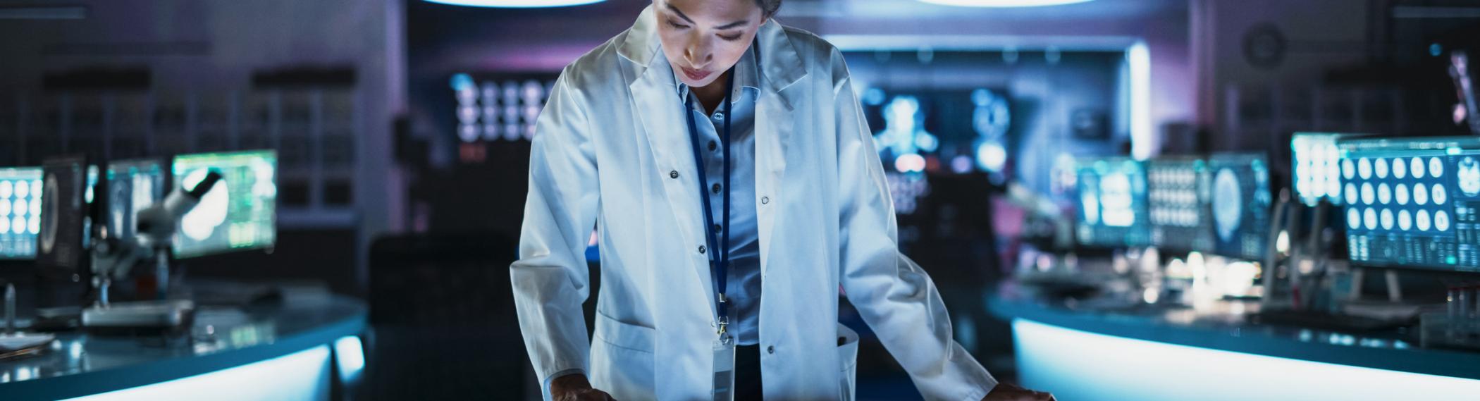 female researcher in a lab looking at brain scans on a monitor