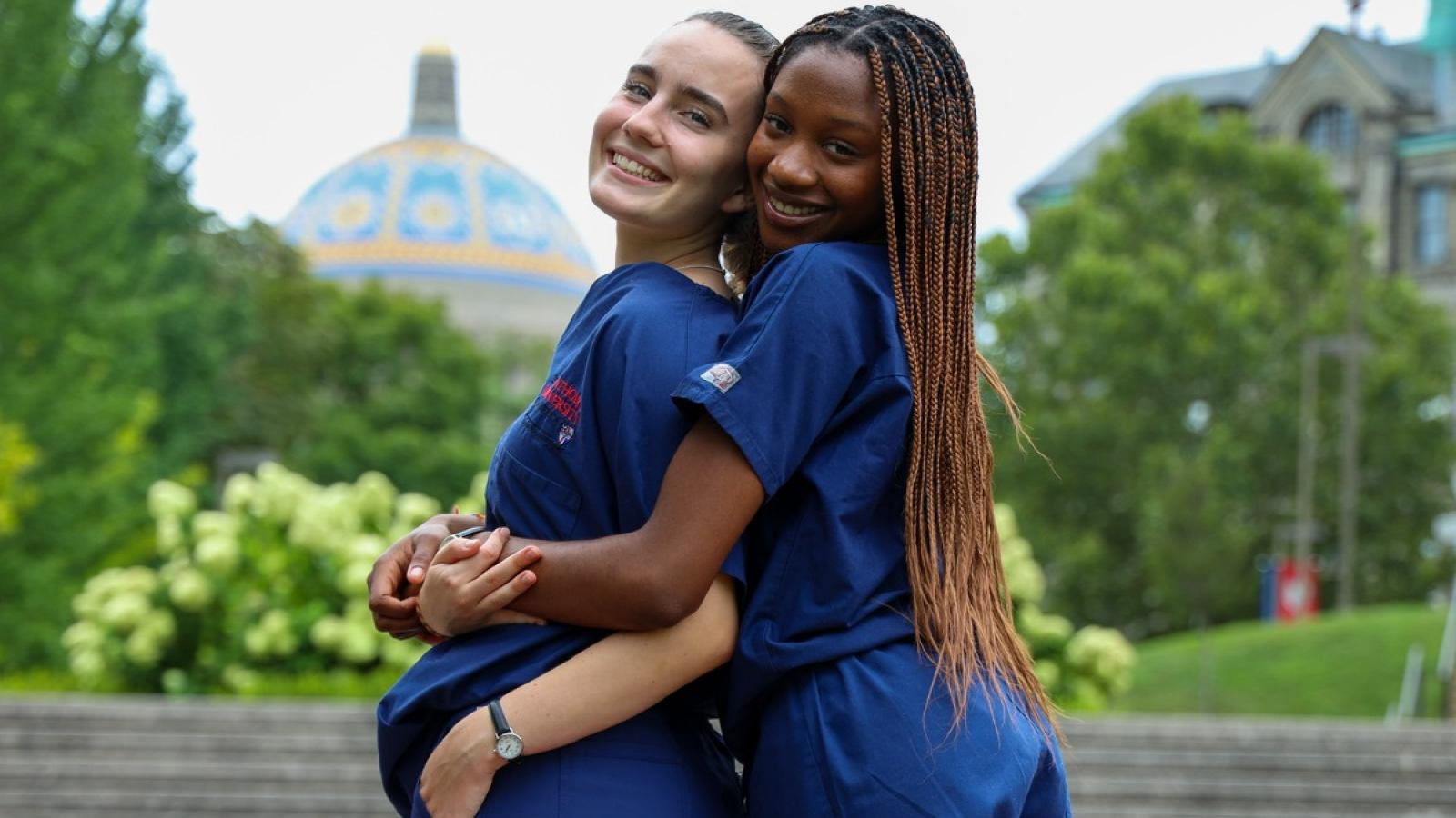 anisa with a friend in their scrubs