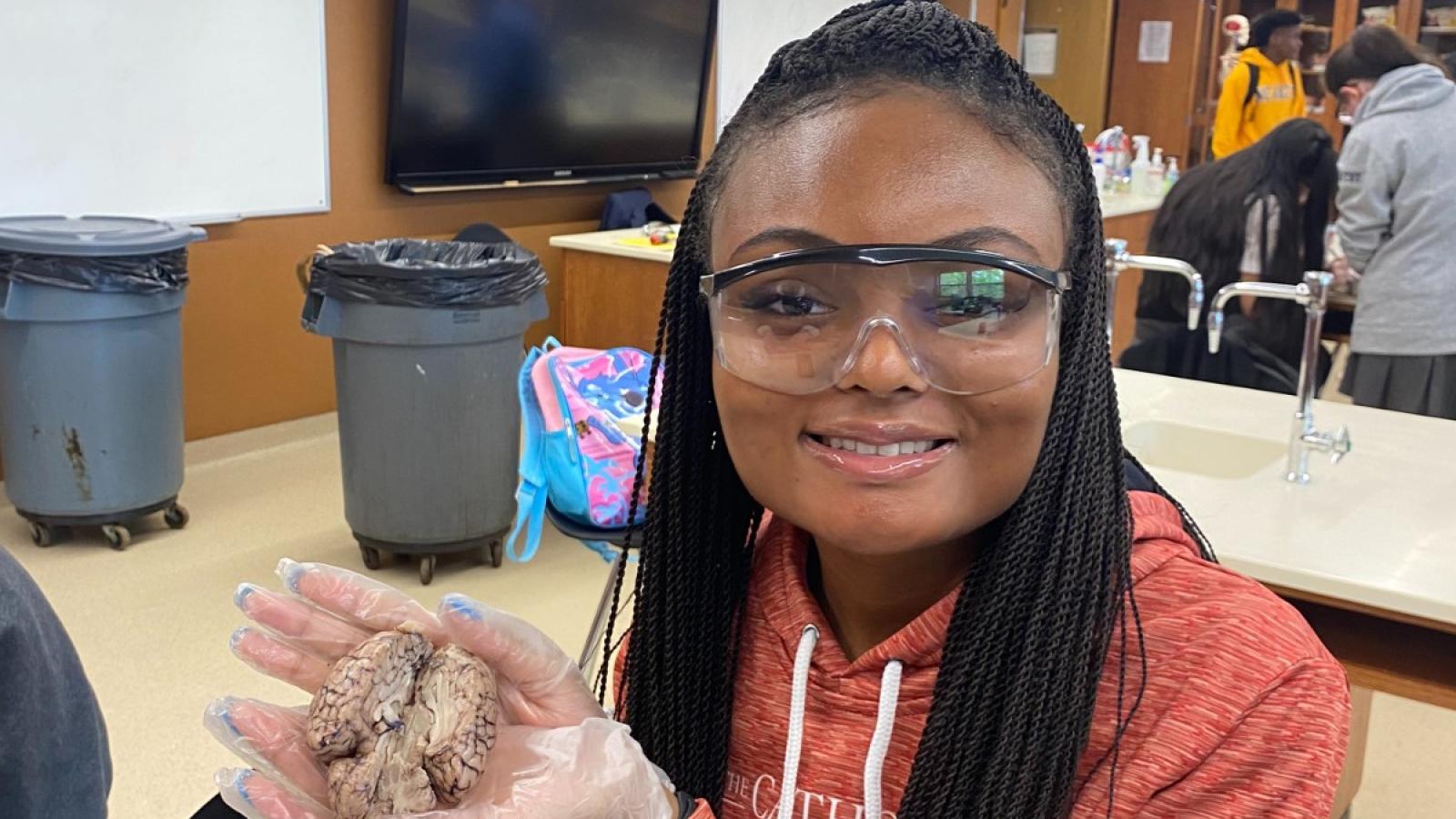 eboni willis holds an animal brain during a class disection