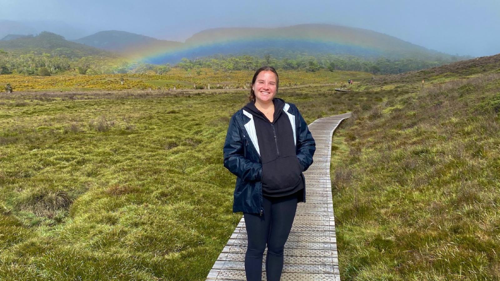sarah in a meadow with a rainbow 