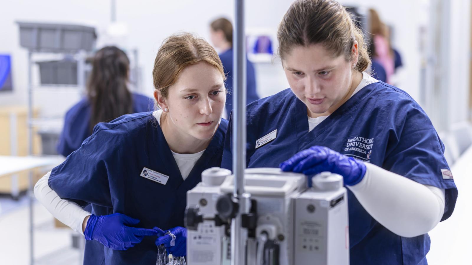 students operating a machine in a simulation area of the conway school of nursing