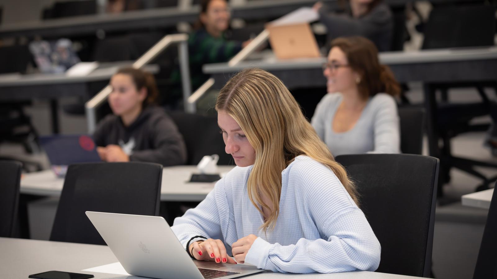 A student at a laptop in the Conway School of Nursing.