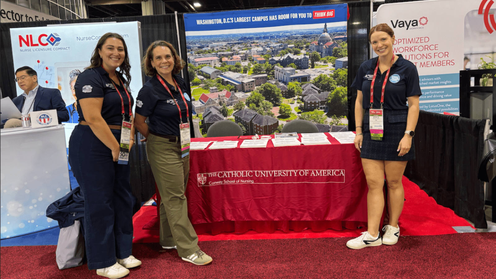 Photo of students in front of the Catholic University table at the conference.