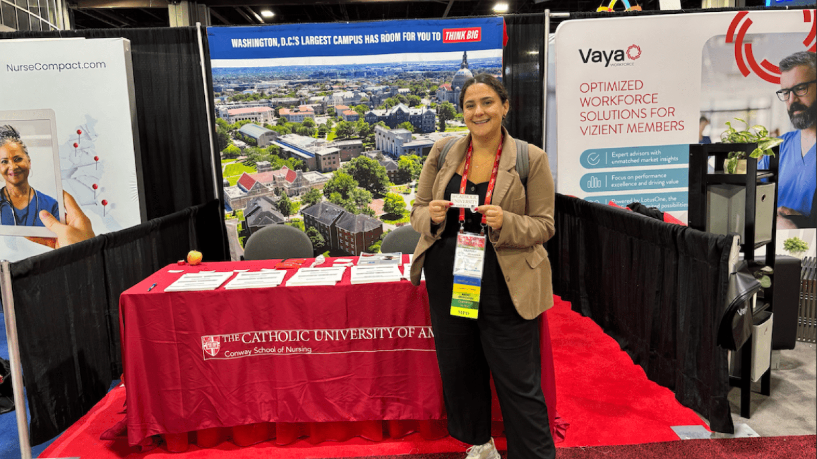 Conway School of Nursing representative standing in front of a table at the conference.
