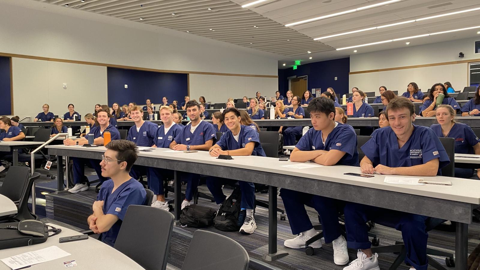 students in the auditorium-like tiered classroom