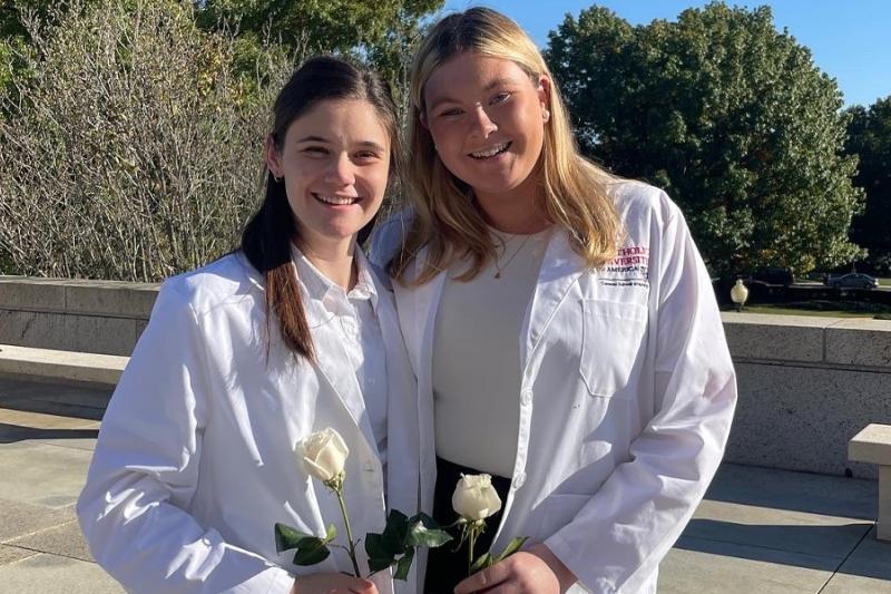 whitney and a friend in their white nursing lab coats