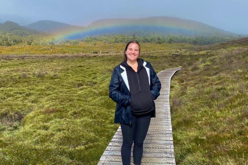 sarah in a meadow with a rainbow 