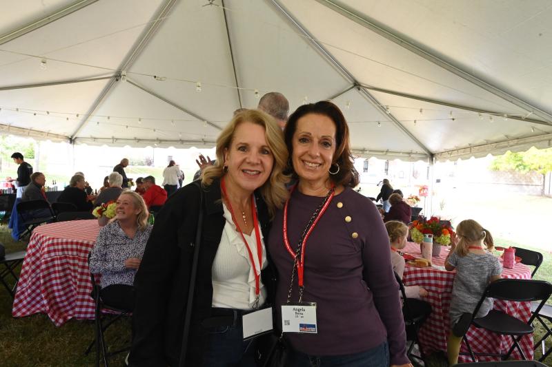 two female alumni pose for a picture together at an event on campus