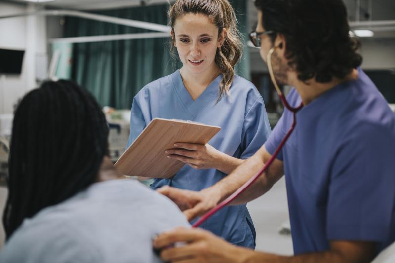 nurse with clipboard checking on a patient