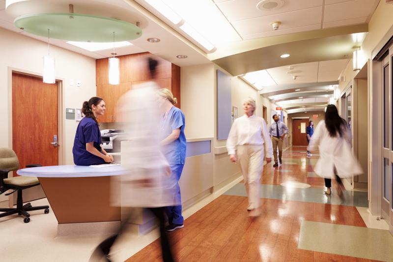 hospital hallway with nurses and doctors swiftly walking by