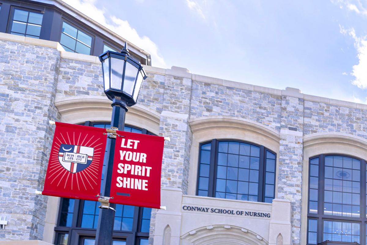 Conway building with single inspirational banner and sky.