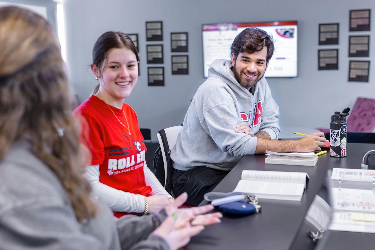 Grad student talking with other students.