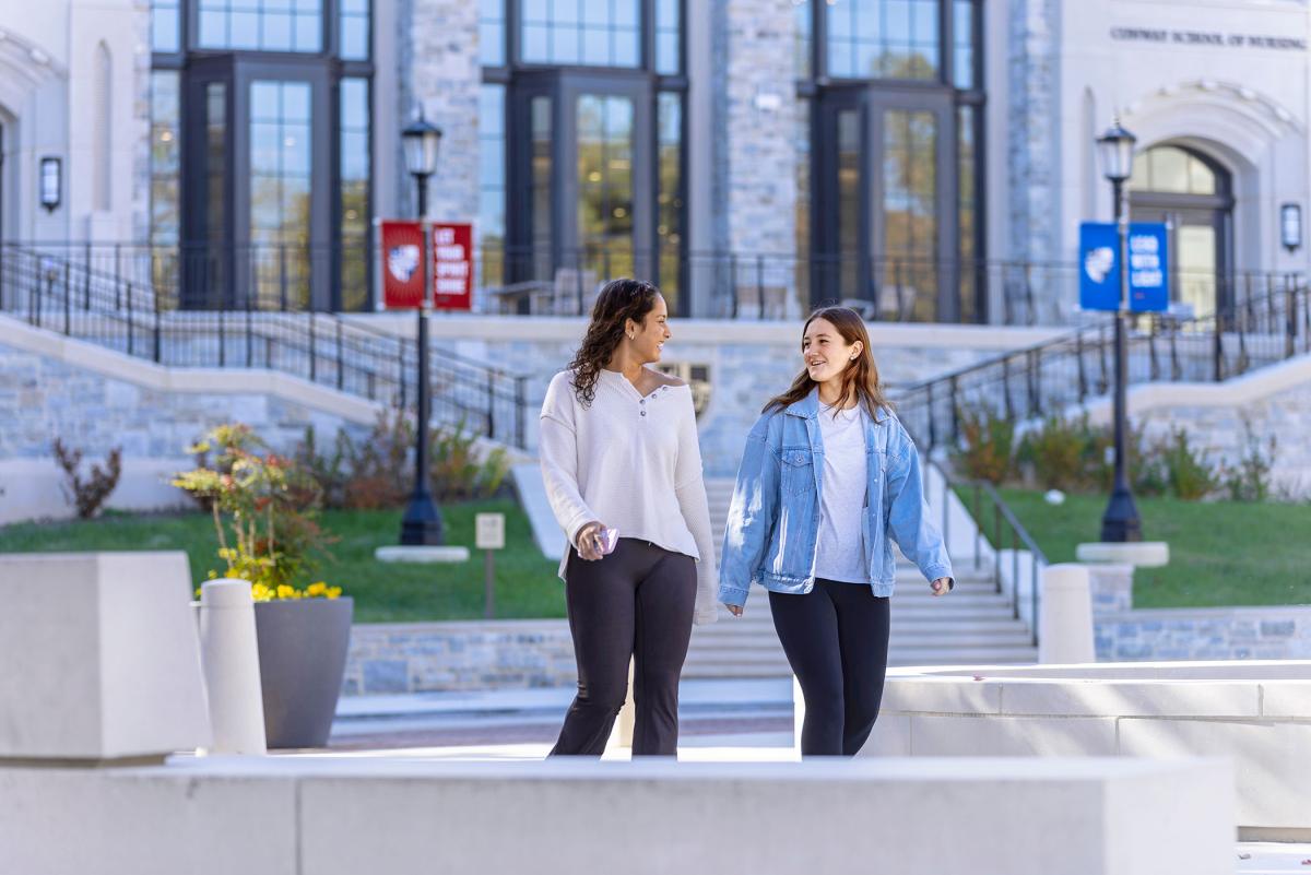 Students walking outside Conway near fountain.