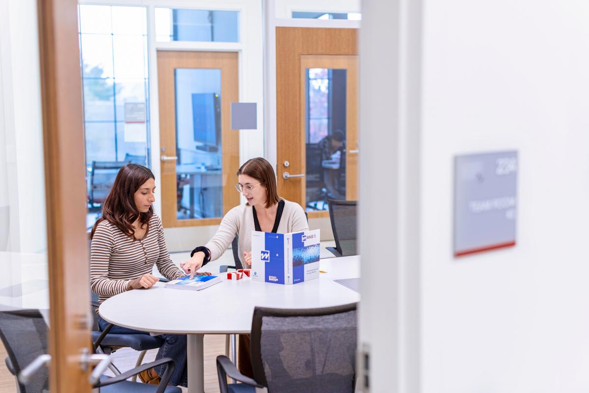 student and peer advising one another at a table