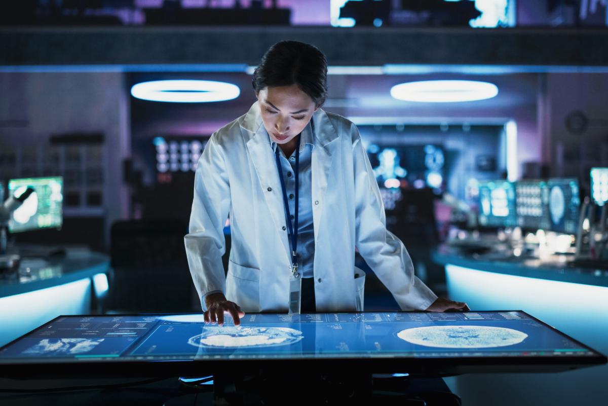 female researcher in a lab looking at brain scans on a monitor