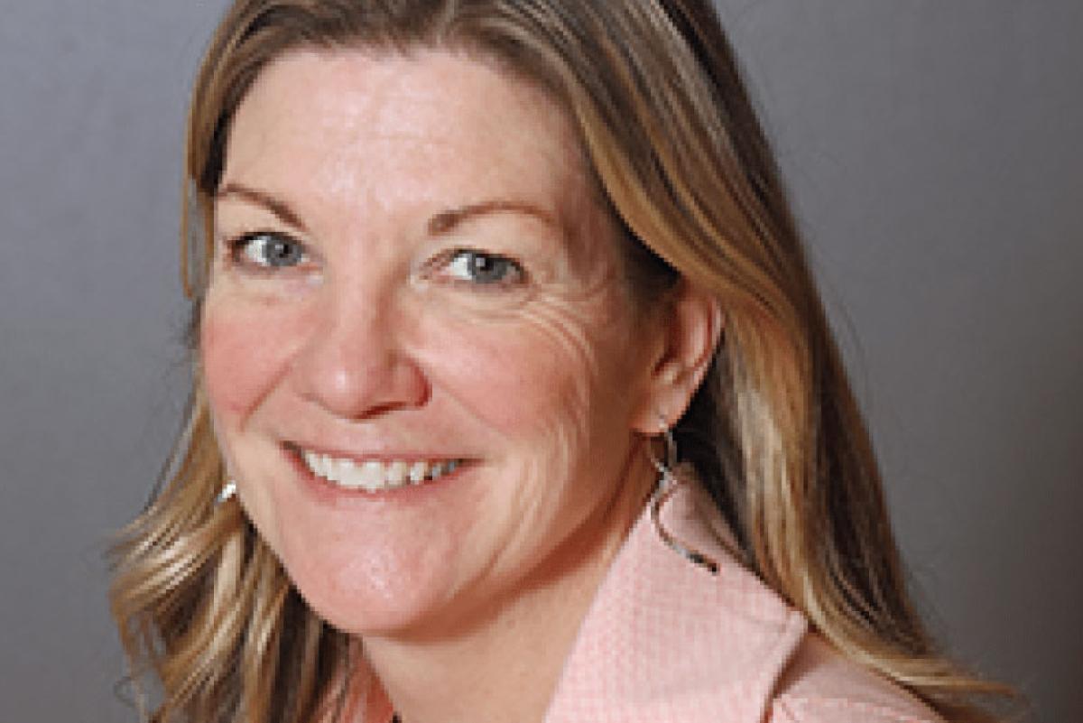 Photo of Cari Selzer. She has long blonde hair and is wearing a pink blazer.