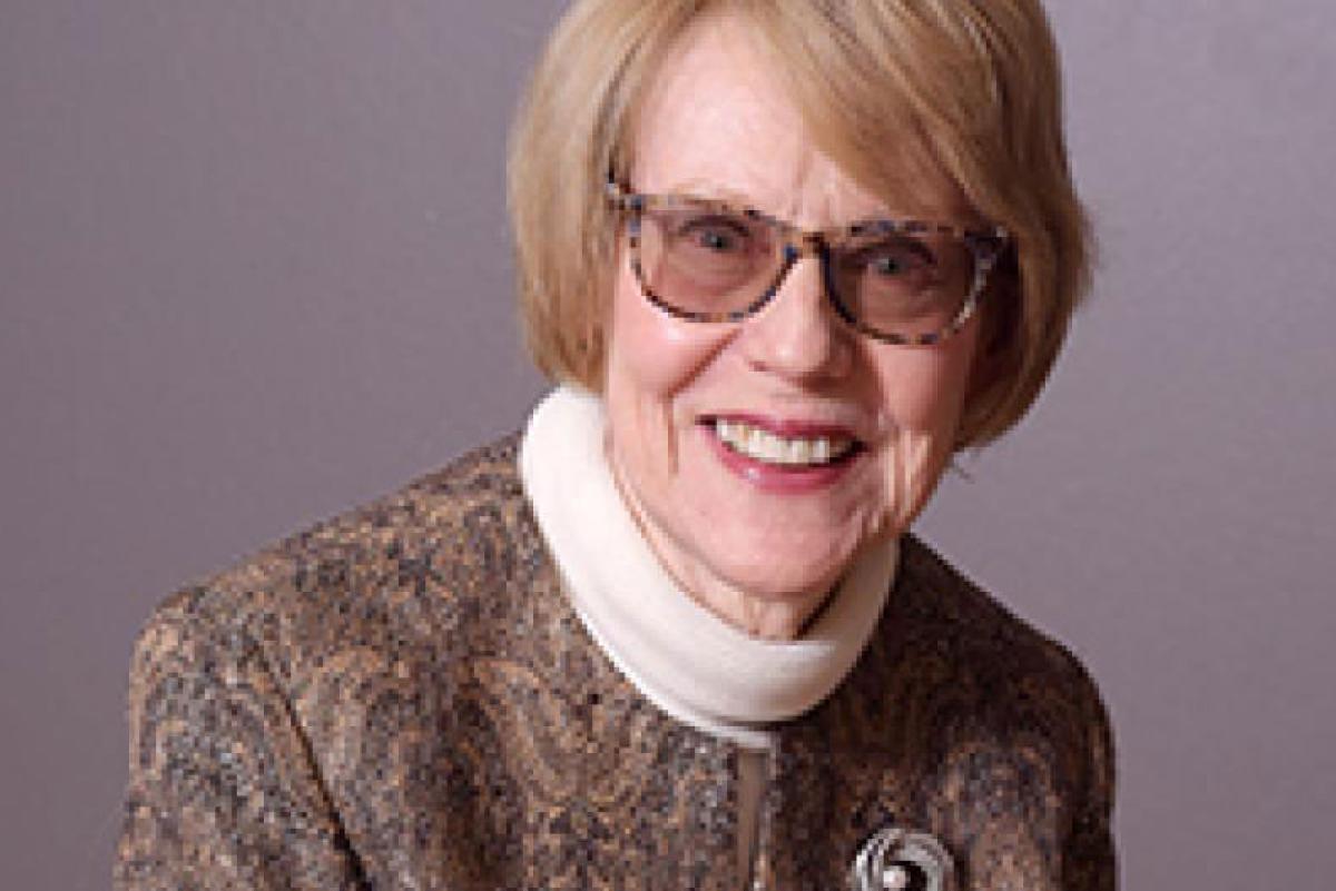 Photo of Eileen Caulfield. She has dark glasses and blonde hair with a paisley and white turtleneck.