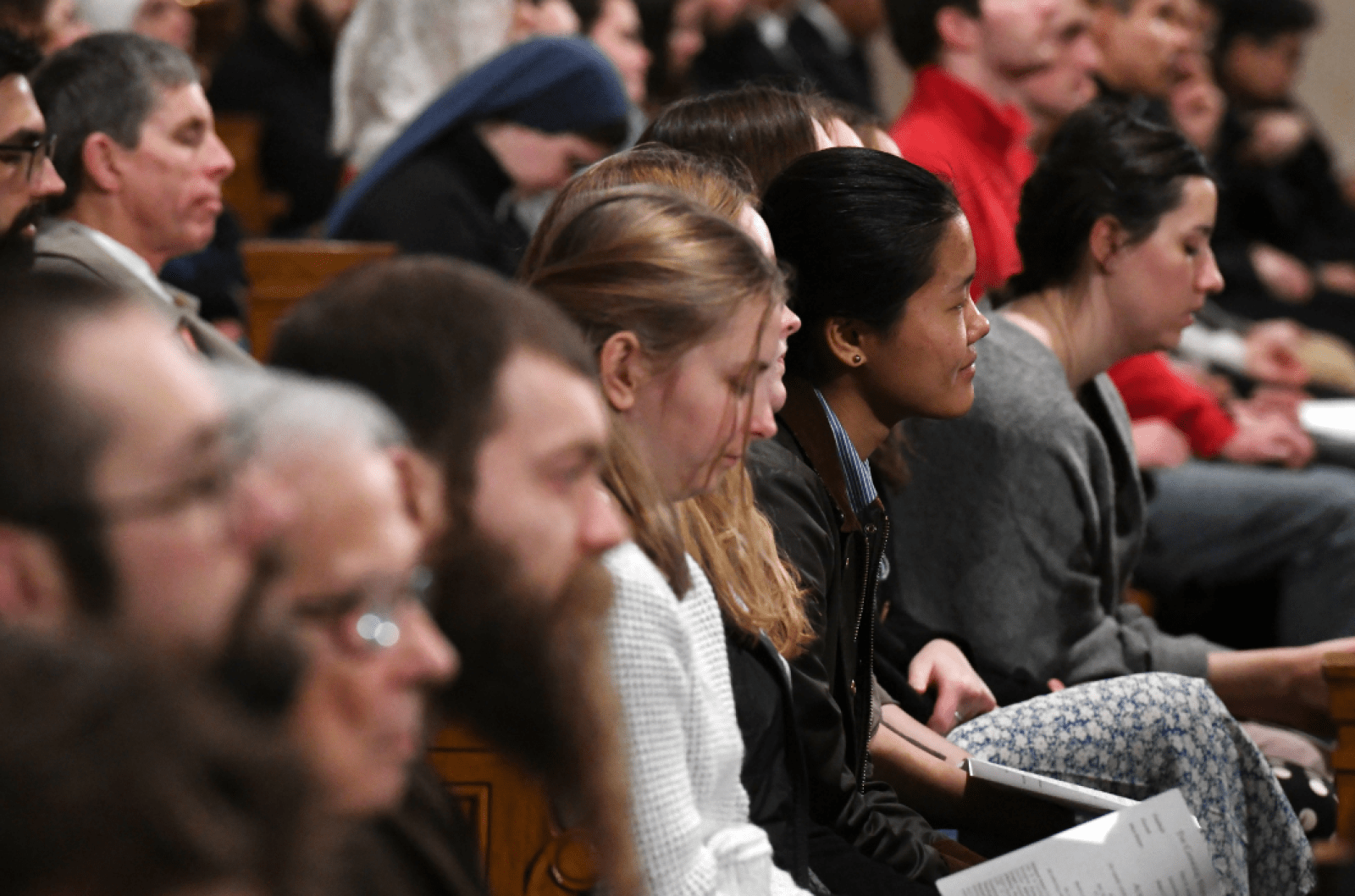 Students and faculty members praying during Mass of St. Thomas Aquinas.