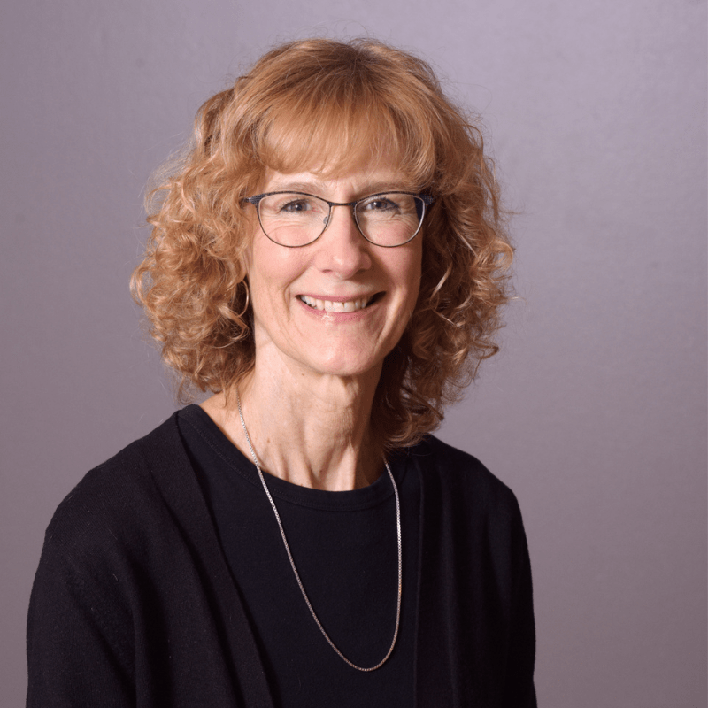 Photo of Rebecca Robert. She has short, curly blonde hair and is wearing a black top.
