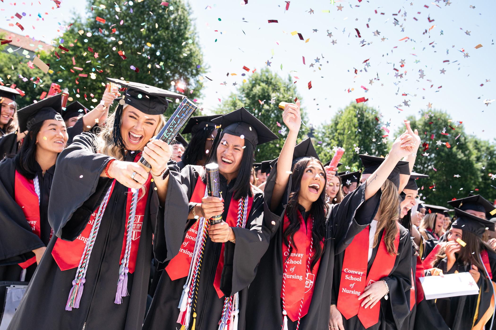nursing students throwing confetti in celebration at their graduation