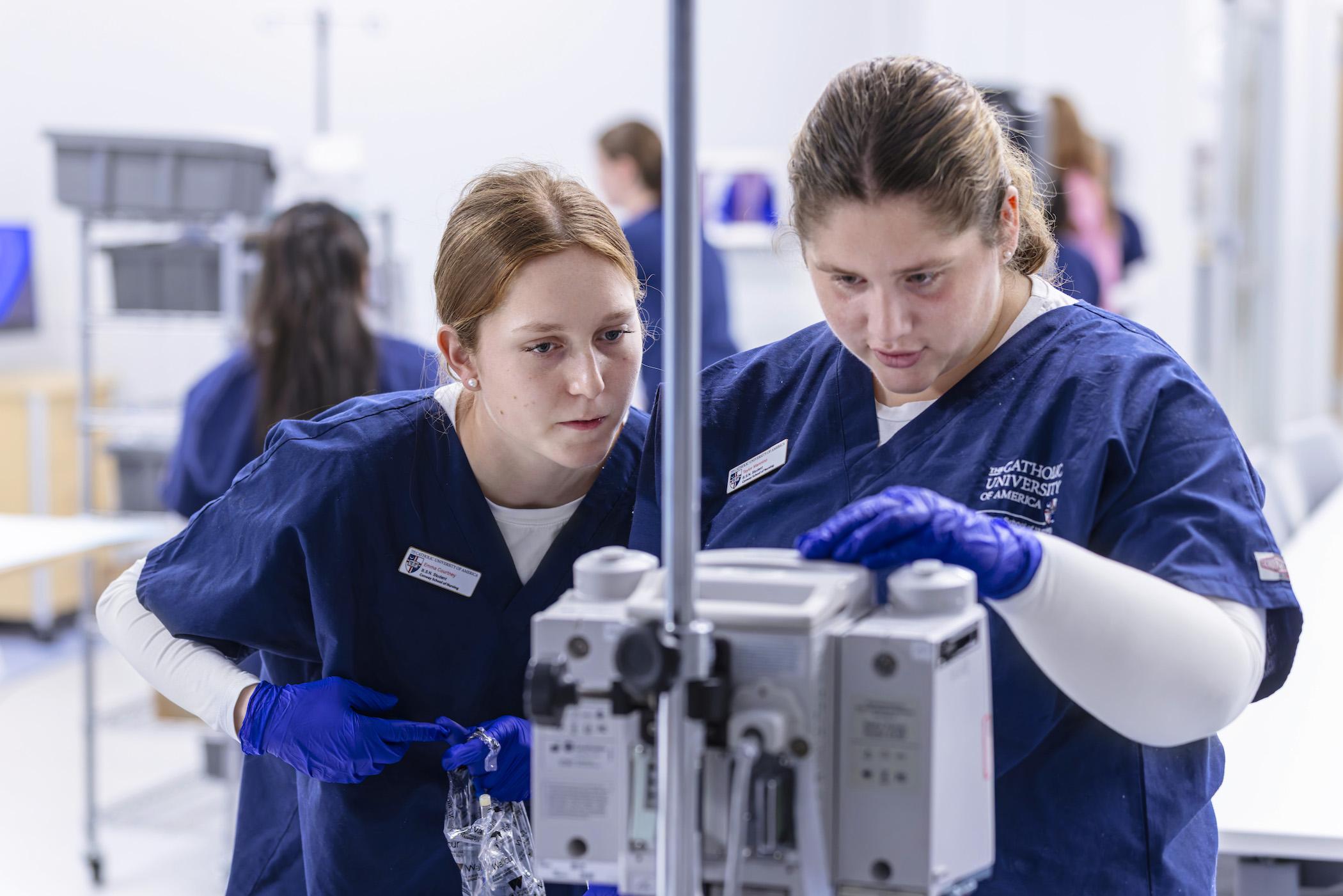 students operating a machine in a simulation area of the conway school of nursing