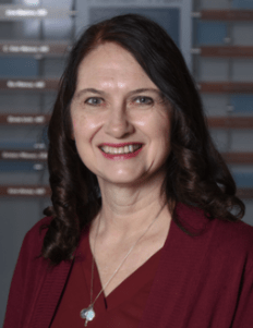 Photo of Dr. Ann Marie Nie. She is wearing a red shirt and has long brown hair.