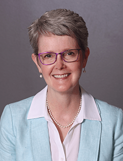 Headshot of Martha Scheckel. She is wearing a white shirt with a baby blue cardigan over it.